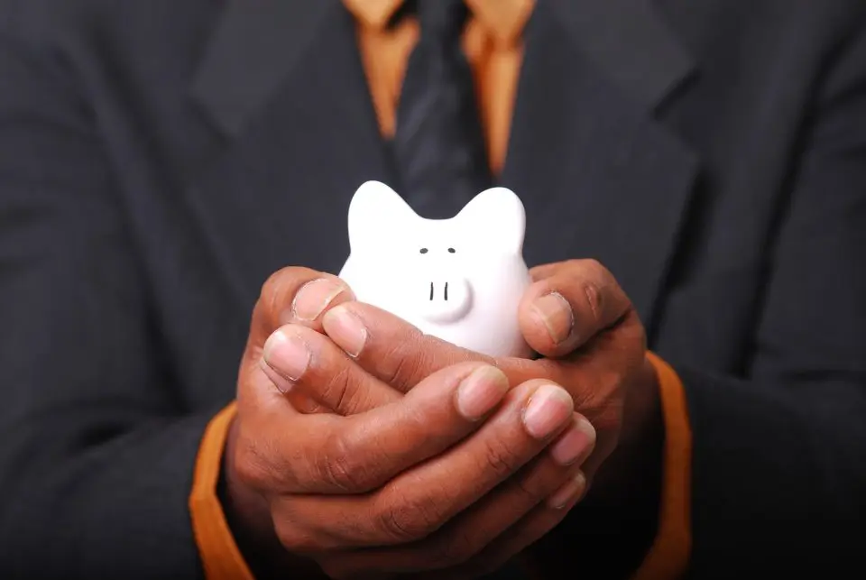 Business hands holding white piggybank