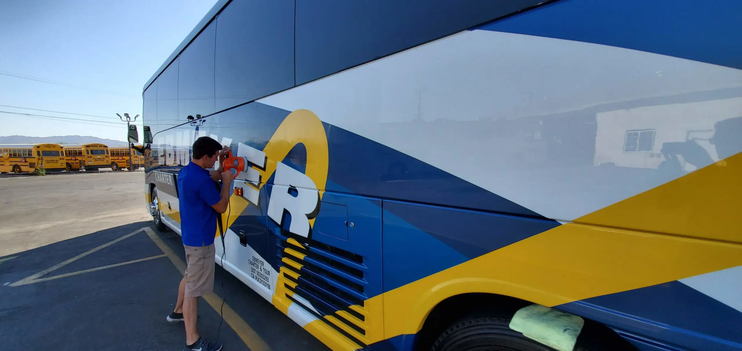 Person cleaning charter bus exterior